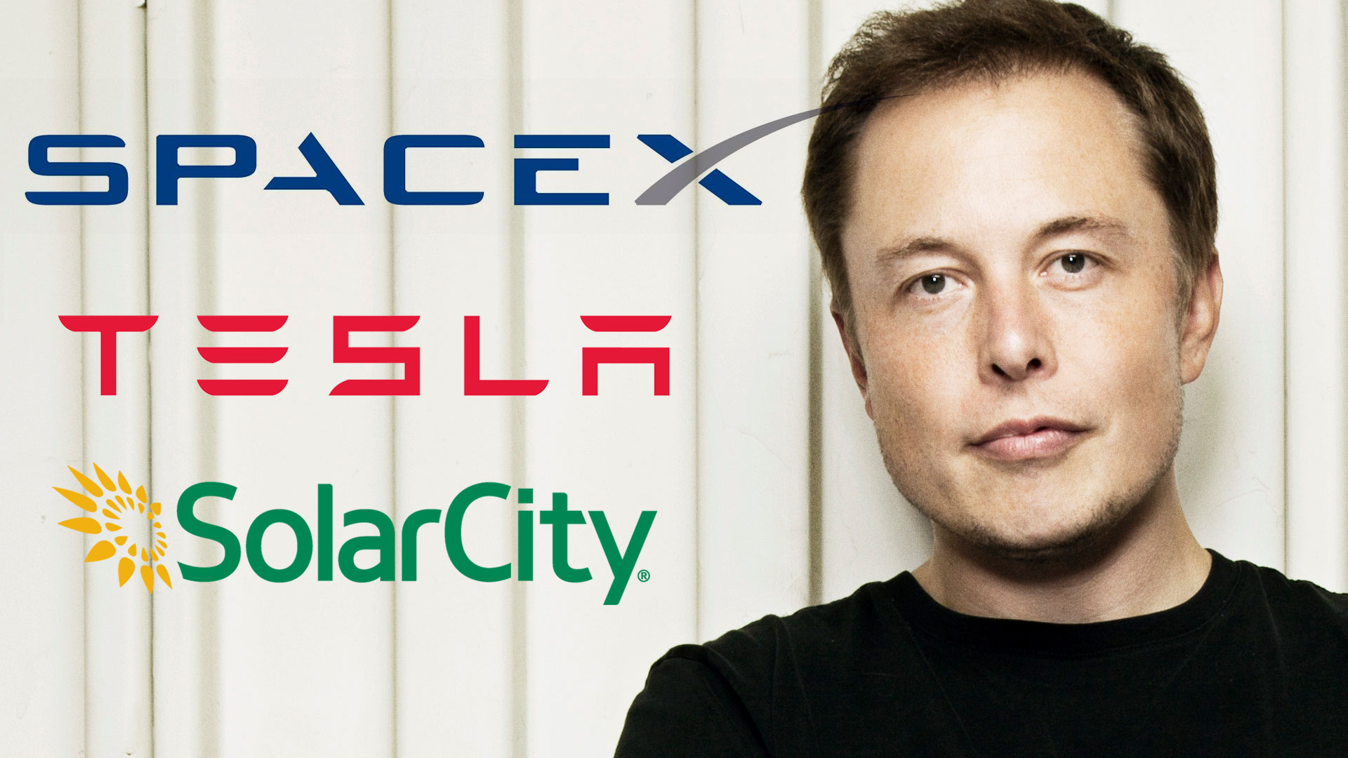 Elon Musk with his three company logos beside him